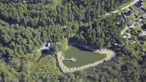 vista aérea del bosque, el estanque y las casas rurales