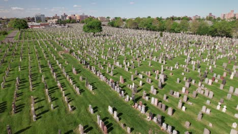 Slow-smooth-drone-pull-out-shot-over-rows-of-graves-in-a-huge-garden-cemetery