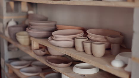 Pottery-woman,-shelf-and-creative-ceramic-cups