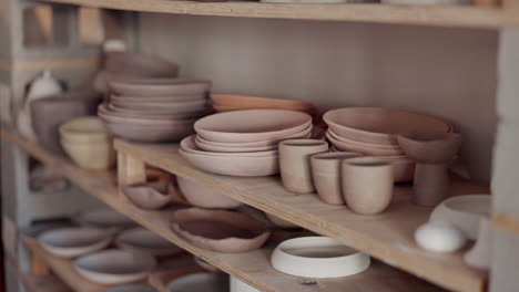 mujer de cerámica, estantería y tazas de cerámica creativas