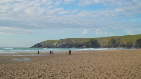 Turistas-En-La-Orilla-De-La-Playa-De-La-Bahía-De-Holywell-En-Cornualles,-Inglaterra---Plano-Amplio