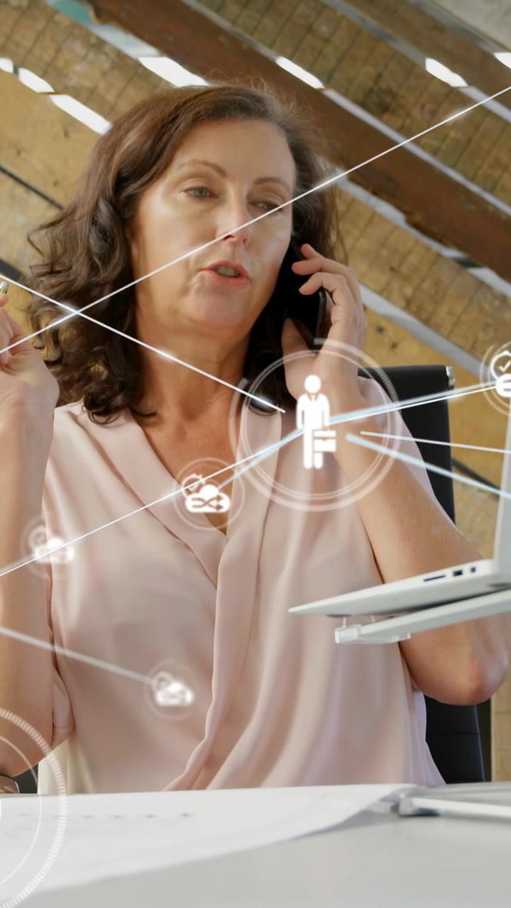 Vertical video: Woman holding phone and on business call in loft, starting HUD radiating from torso