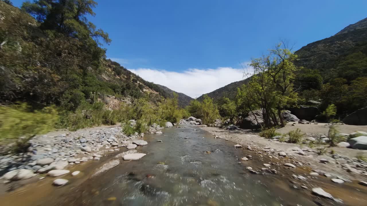 volando a lo largo del lecho del río en el cañón rocoso del maipo en chile, disparo de vuelo bajo fpv