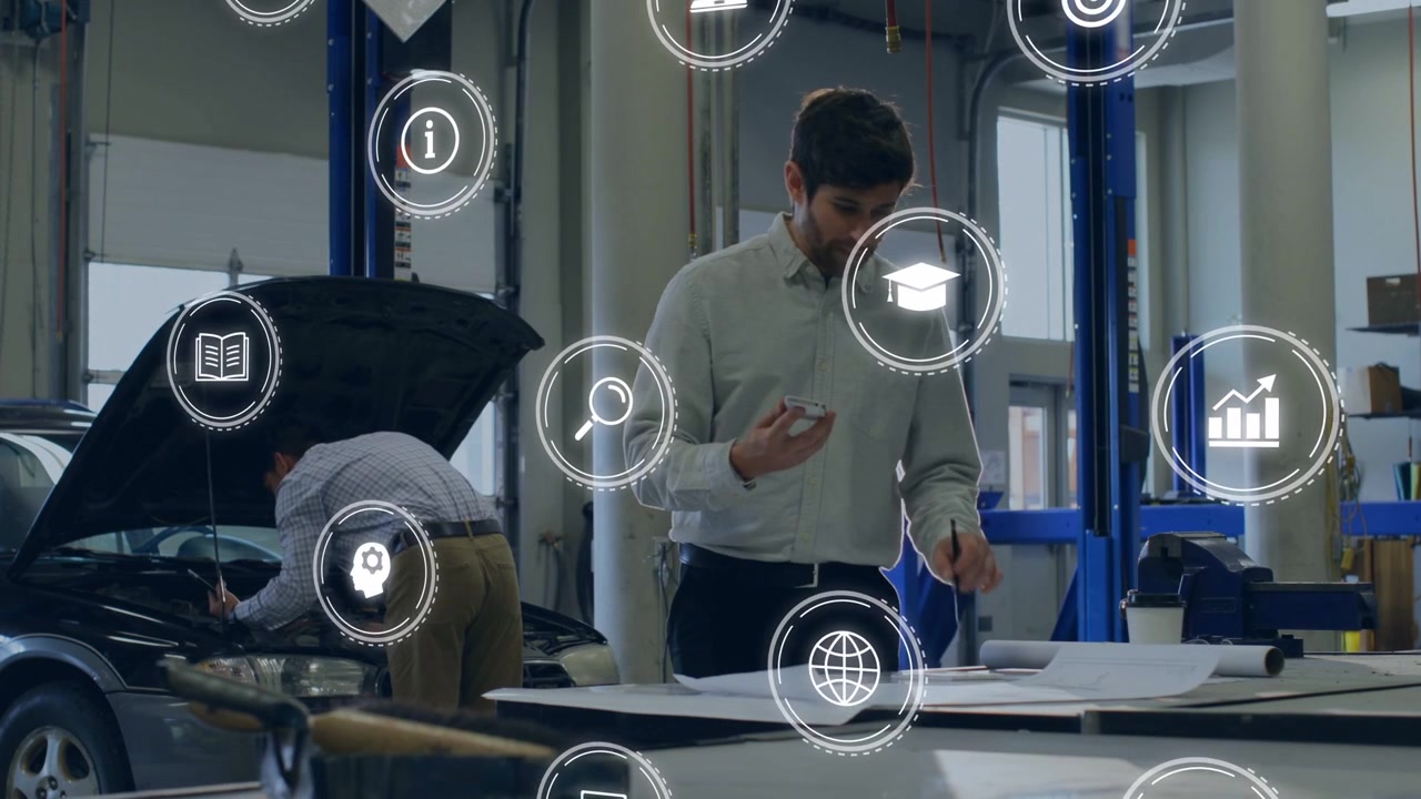 Man scanning plans on phone, spawning AR icons while auto tech repairing engine for diagnostic work