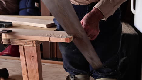 man sawing wood in garage - close up