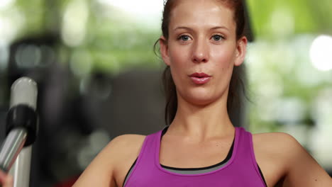 mujer en forma usando una máquina de pesas
