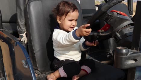 una expresión linda de un niño inocente jugando con el mango del coche durante el día desde un ángulo plano. el video fue tomado en rajasthan, india.