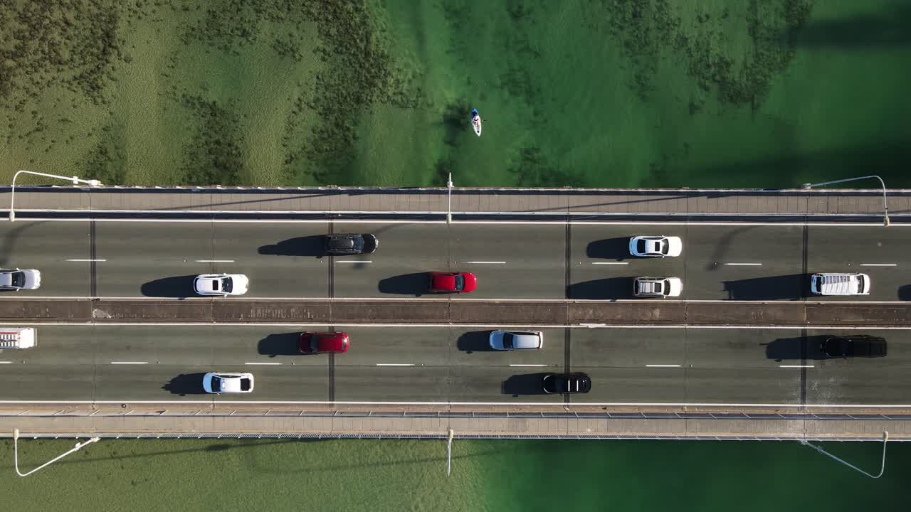 i kayak scivolano sotto un ponte urbano affollato che si estende sulle limpide acque dell'estuario dell'oceano