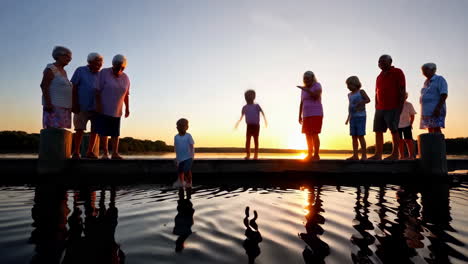 grandparents and grandchildren enjoying a sunset by the lake