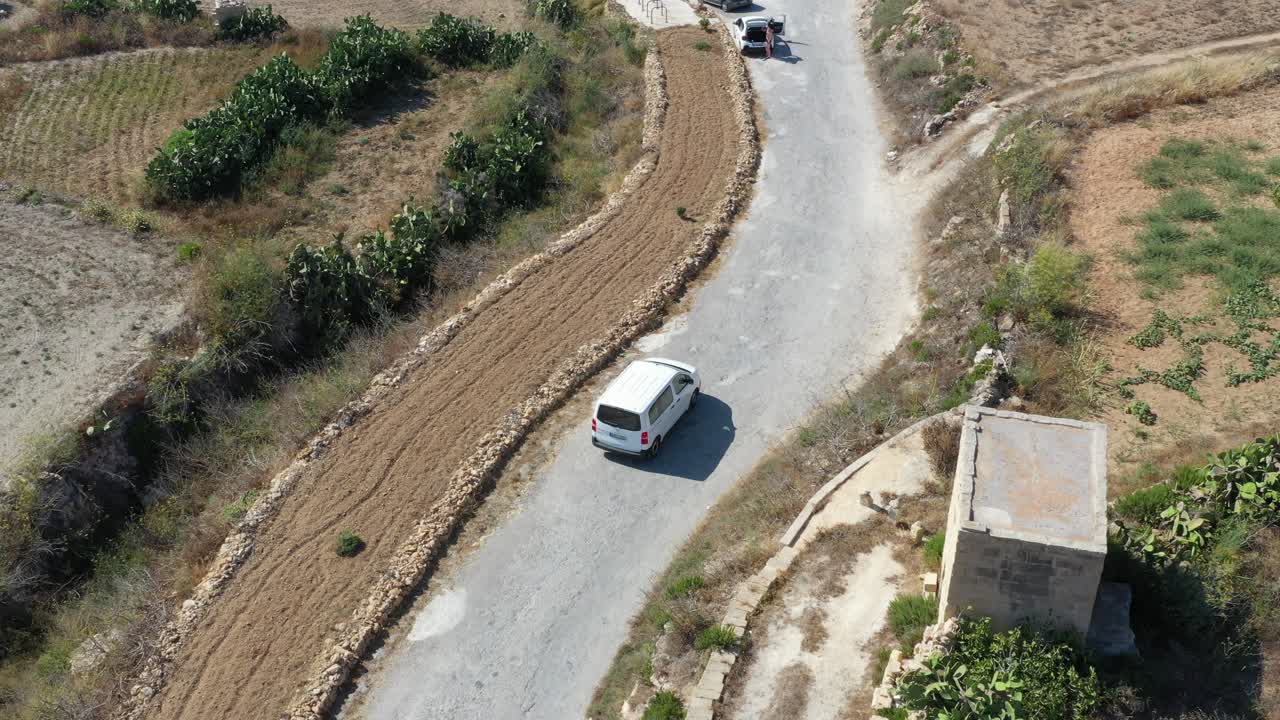 Riprese aeree con drone di un'auto su strada verso Wied il-Għasri a Malta.