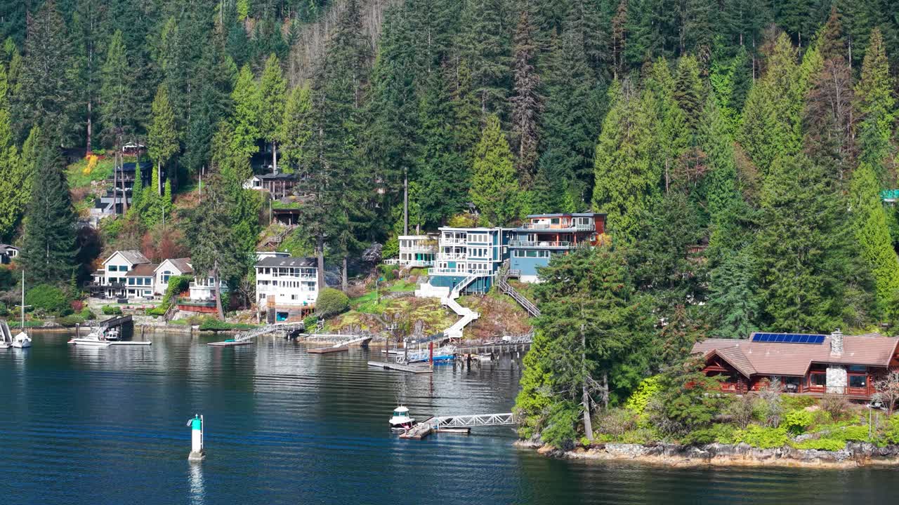 an aerial drone shot of luxury homes with their own private dock in Indian River Drive, North Vancouver