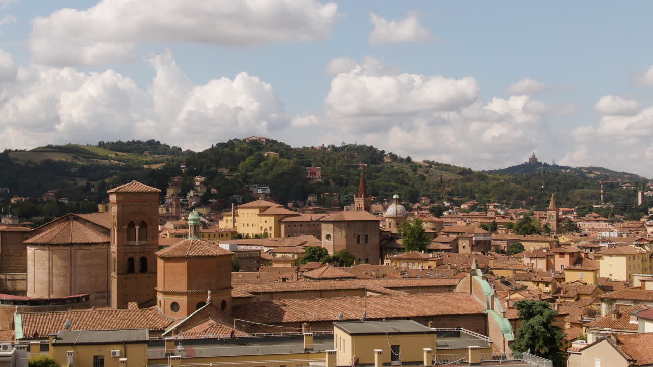 edificio de estilo italiano en la ciudad de bolonia con colina forestal en el fondo, vista aérea descendente
