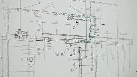 hands working on an engineering blueprint with a ruler and pencil