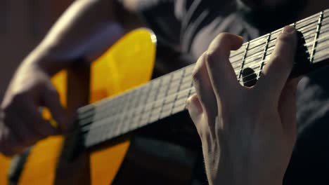 un joven tocando hábilmente la guitarra clásica con técnica avanzada en ambas manos.