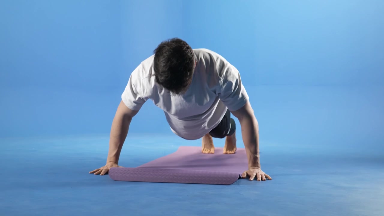 Giovane uomo che esegue flessioni su tappetino da yoga