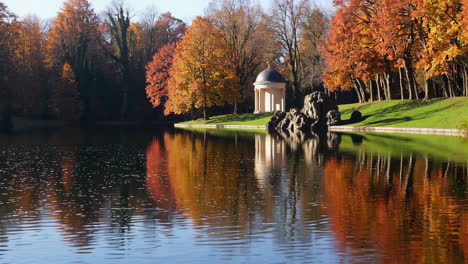 autumn park with lake and pavilion reflection