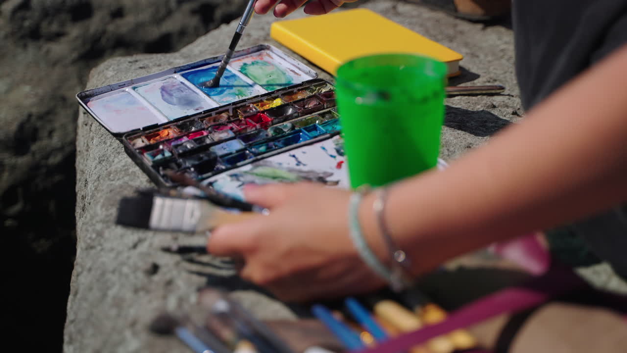 artista pintando al aire libre en las rocas