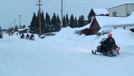 A-snowmobile-rides-his-snowmobile-through-a-town