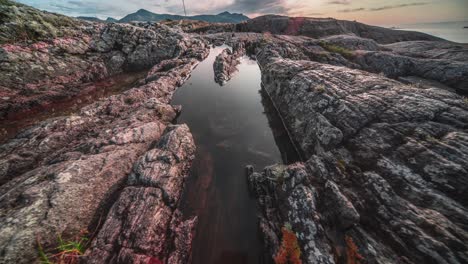 the setting sun is reflected in the still water of the tide pool on the atlantic coast