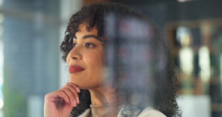 Thoughtful Businesswoman Looking Through Office Window