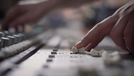 close up shot of the professional musician hands, people create music on the mixer with the help of the movement of the sliders responsible for the melody