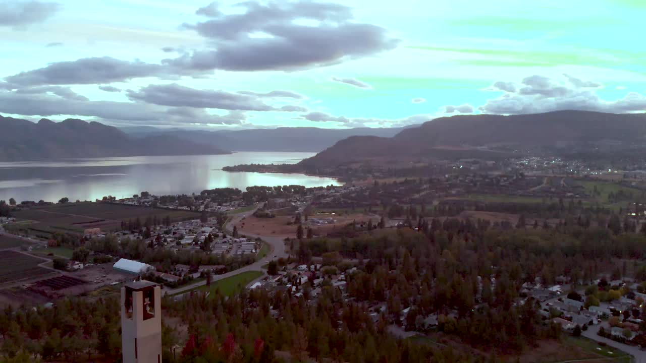 una pequeña torre conduce a un pueblo que descansa al lado de un río del valle