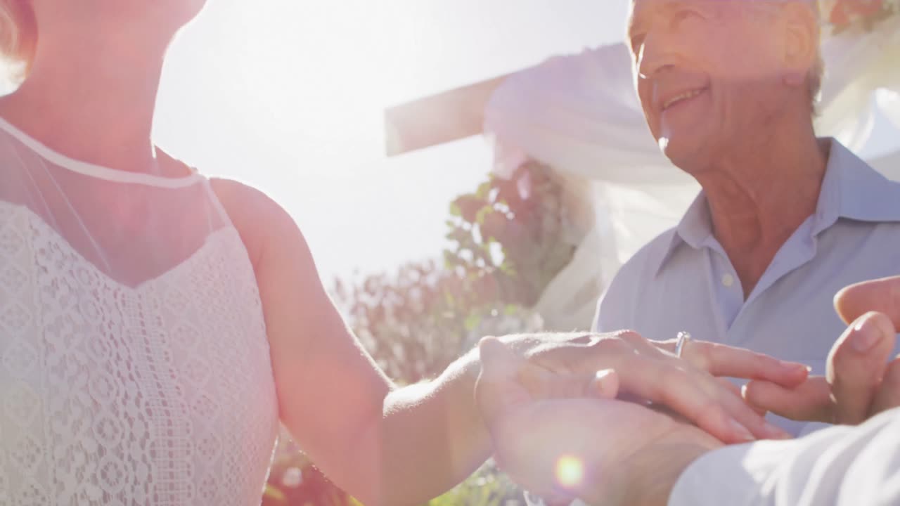 백인 신부 와 신랑 이 의식 중 결혼식 의 담당자 와 함께 야외 제단 에 서 있다