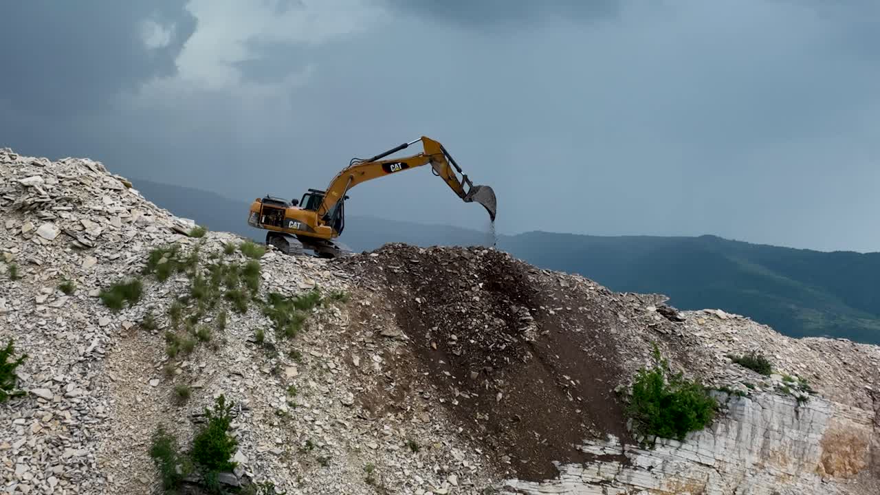 excavadora cavando en el lado de la montaña y limpiando escombros