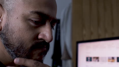 a close up shot of an anxious indian man subconsciously stroking his facial hair while deep in thought on trying to resolve a business issue in his mind