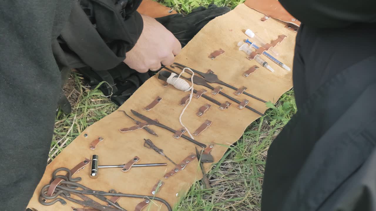 escena larp: un médico mostrando una colección de herramientas de un kit quirúrgico portátil