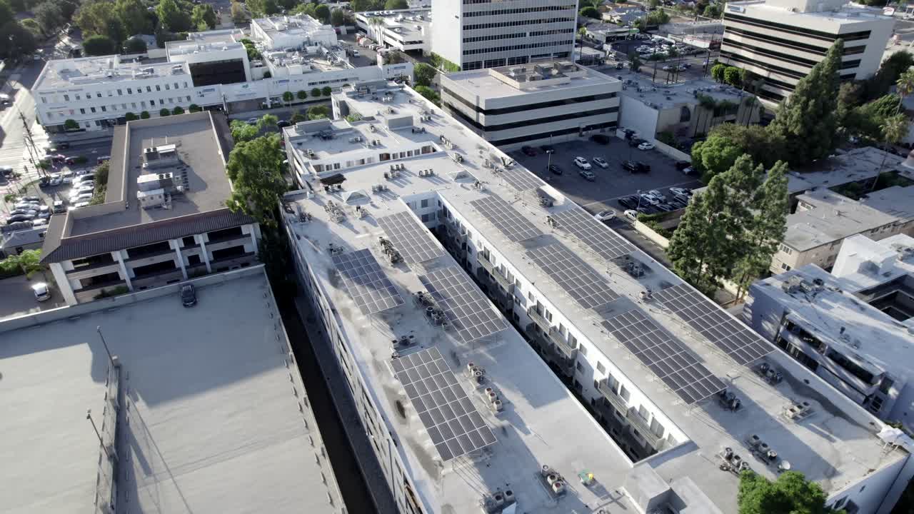 Tecnologia aérea de painéis solares verdes alternativos em edifício de apartamentos residencial na cidade, filmagem de drone