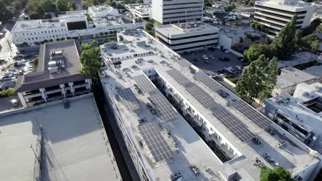 aerial green alternative solar panel technology on residential apartment building in city, drone shot