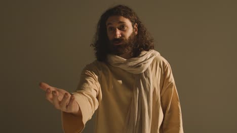 hombre con túnicas con cabello largo y barba que representa la figura de jesucristo predicando o orando