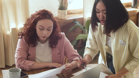 Mujer-Joven-Discutiendo-Ideas-Con-Sus-Dos-Colegas-Durante-Una-Reunión-De-Equipo