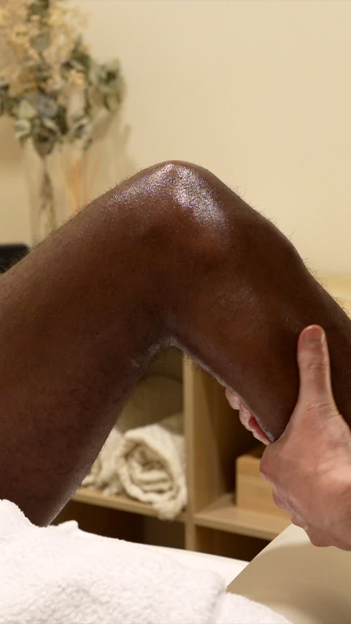 Massaggiatrice professionista che esegue un massaggio rilassante alle gambe su un cliente