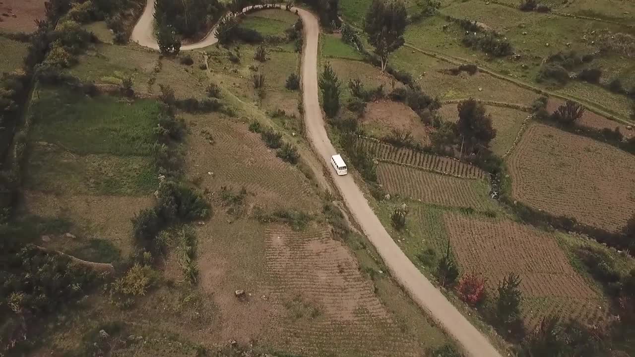 vista aérea cinematográfica de una furgoneta conduciendo a través de las tierras de cultivo de perú, viaje por carretera de conducción panorámica