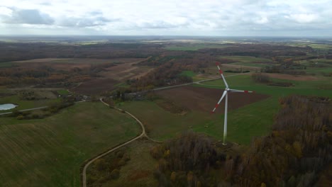 aerial shot of spinning wind turbine with red edges for renewable electric power production in a field