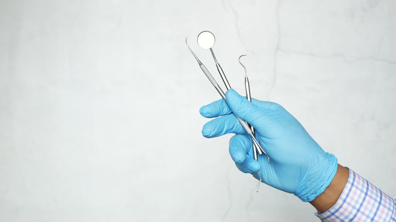 herramientas dentales en guantes azules
