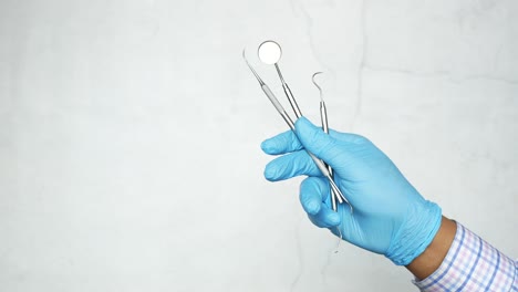 dental tools held in blue gloves