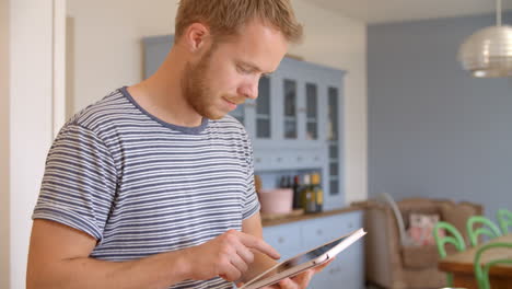 man follows recipe on digital tablet in kitchen shot on r3d