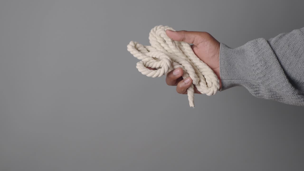 Hand Holding a Piece of Rope