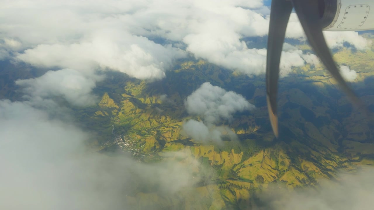 Naturskøn udsigt fra flyvindue over Colombias Amazonas regnskov med roterende propeller over frodig tropisk skov og skyer