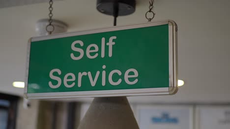 green self service sign hanging indoors