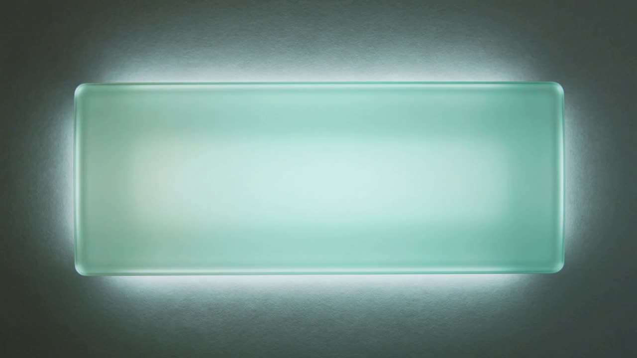 Frosted panel mounted on gray wall showing shifting teal-pink gradients, LED cycling gallery light