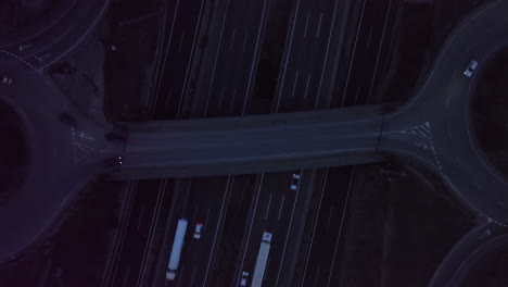 vista aérea que se eleva durante la noche vehículos de tráfico que viajan en una autopista ocupada paso elevado de intercambio