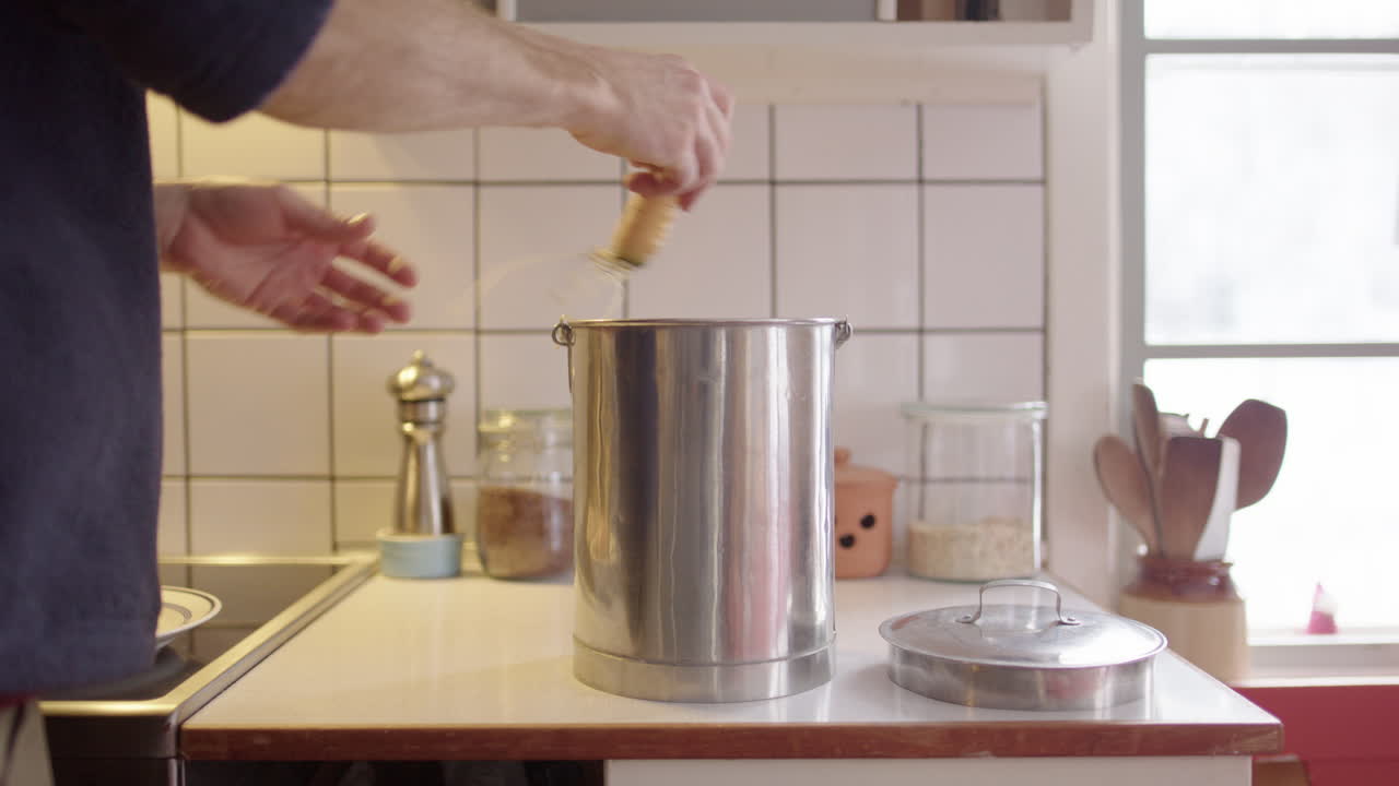 Organic vegetable food waste discarded by unrecognizable male into compost bin