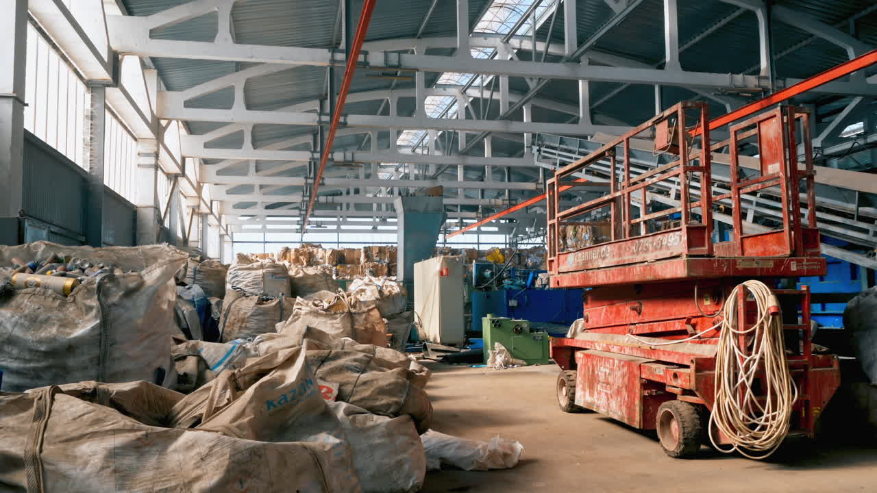 View of interior of a waste sorting plant. Sacks with garbage everywhere, special tools