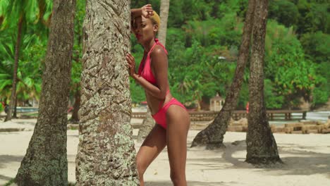 una playa del caribe se convierte en una escena vibrante cuando una chica negra la adorna con un bikini rojo.