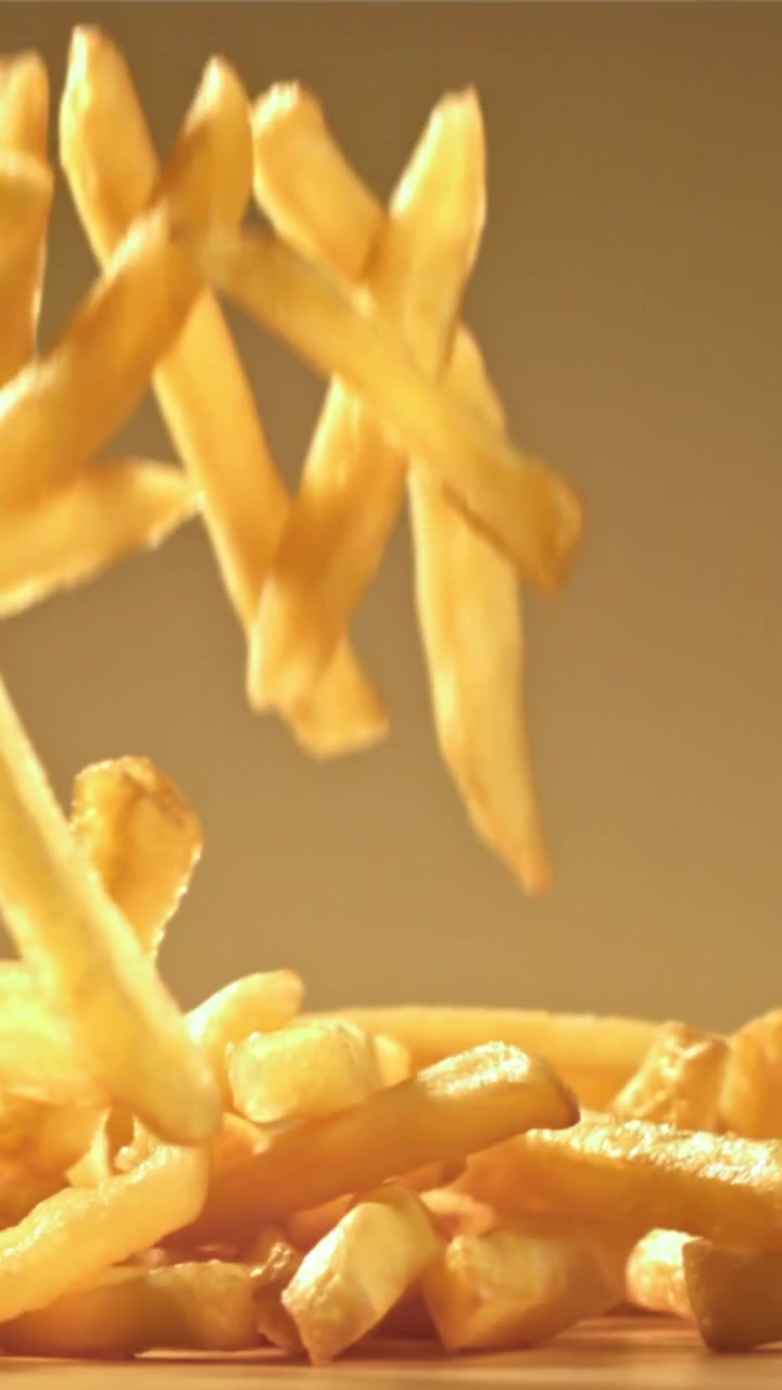 Papas fritas doradas y crujientes cayendo en cámara lenta