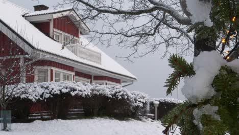 Beautiful-snow-covered-home-during-winter-while-its-snowing